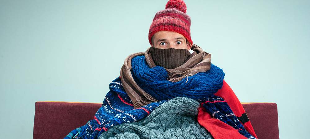 Bearded sick man with flue sitting on sofa at home or studio covered with knitted warm clothes. Illness, influenza, pain concept. Relaxation at Home. Healthcare Concepts. - © Adobe Stock/master1305